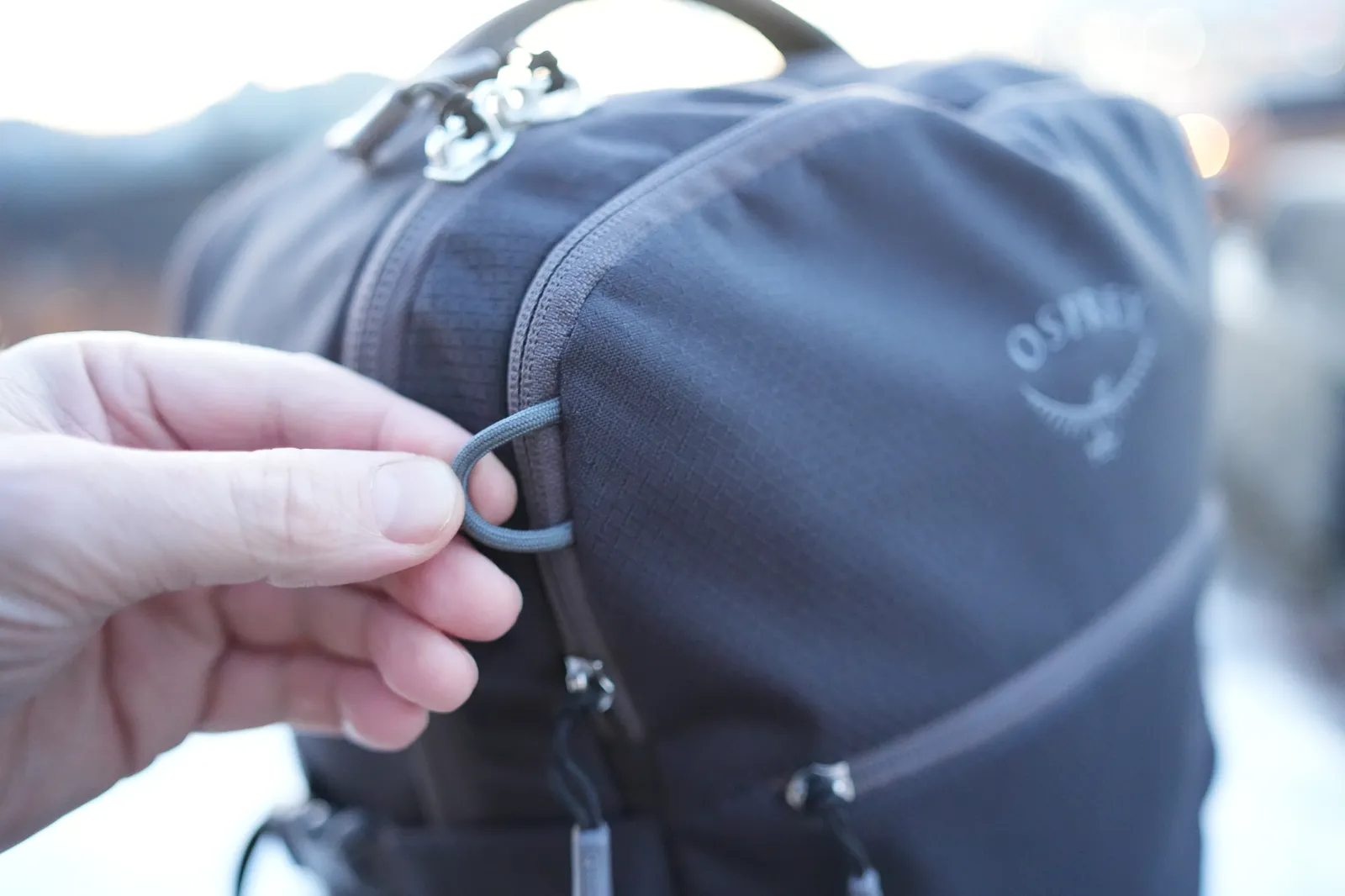 Close-up of the D-ring attachment point on the Osprey Daylite 35 with the Osprey logo visible in the background