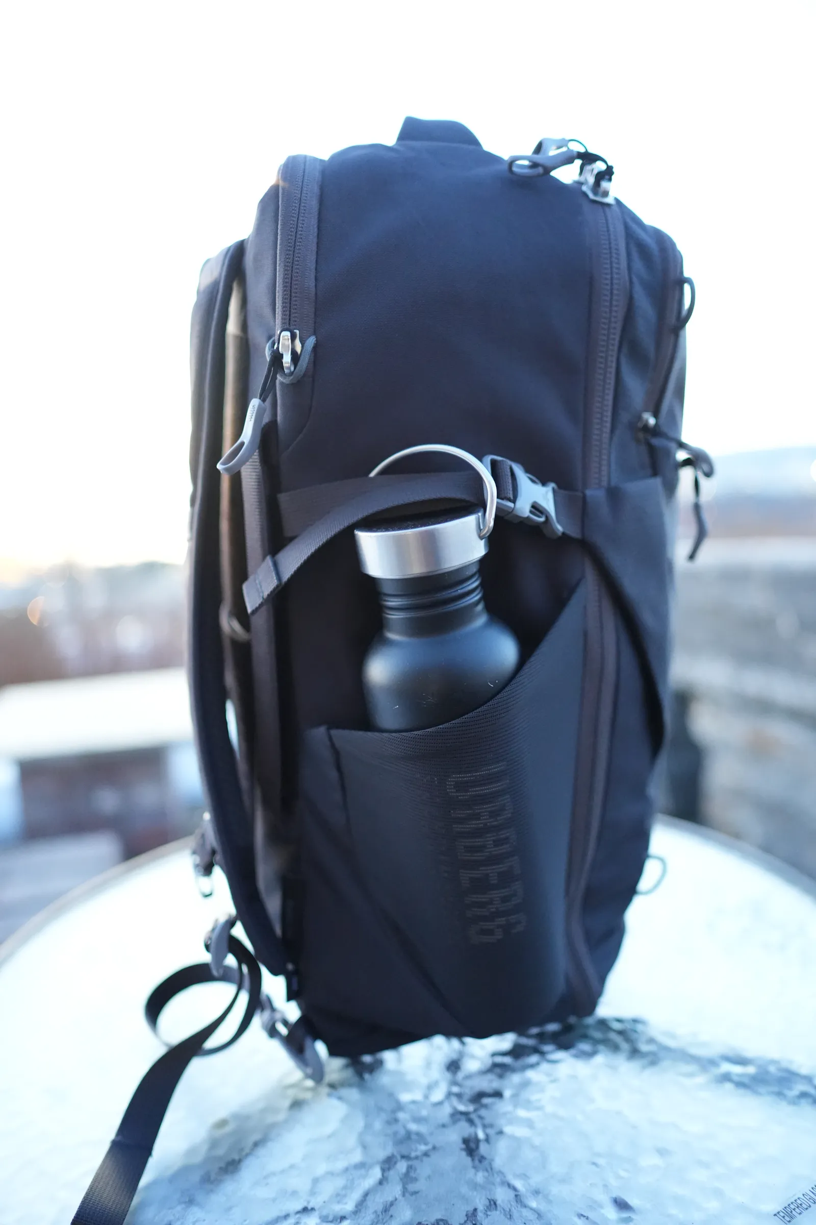 Water bottle secured in the Osprey Daylite 35 side pocket with compression strap holding it in place